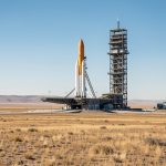 Quels livres choisir pour raconter l’histoire du cosmodrome de Baïkonour ? Vue documentaire réaliste d'une rampe de lancement historique du cosmodrome de Baïkonour au milieu de la steppe kazakhe, sous un ciel bleu dégagé.