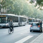 Rue urbaine paisible avec une femme à pied, un homme à vélo, un bus, une voiture électrique discrète et deux adultes en covoiturage.