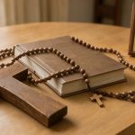 Symboles chrétiens à offrir : choisir un cadeau porteur de sens Composition lumineuse d’une croix, d’une Bible fermée, d’un chapelet et d’une icône posés sur une table en bois clair.